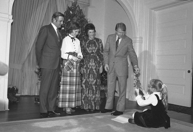 Illustration for article titled 70 Years of First Ladies Standing in Front of Christmas TreesÂ